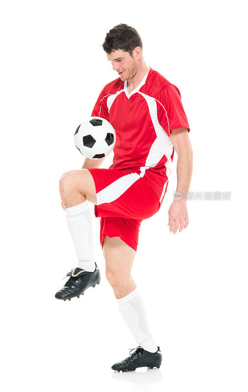 全身/一人/侧视图/ 30-39岁英俊的人的侧面视图高加索男性/中年成年男子/中年成人足球运动员杂耍/踢在白色背景穿着足球制服谁是微笑/快乐/愉快